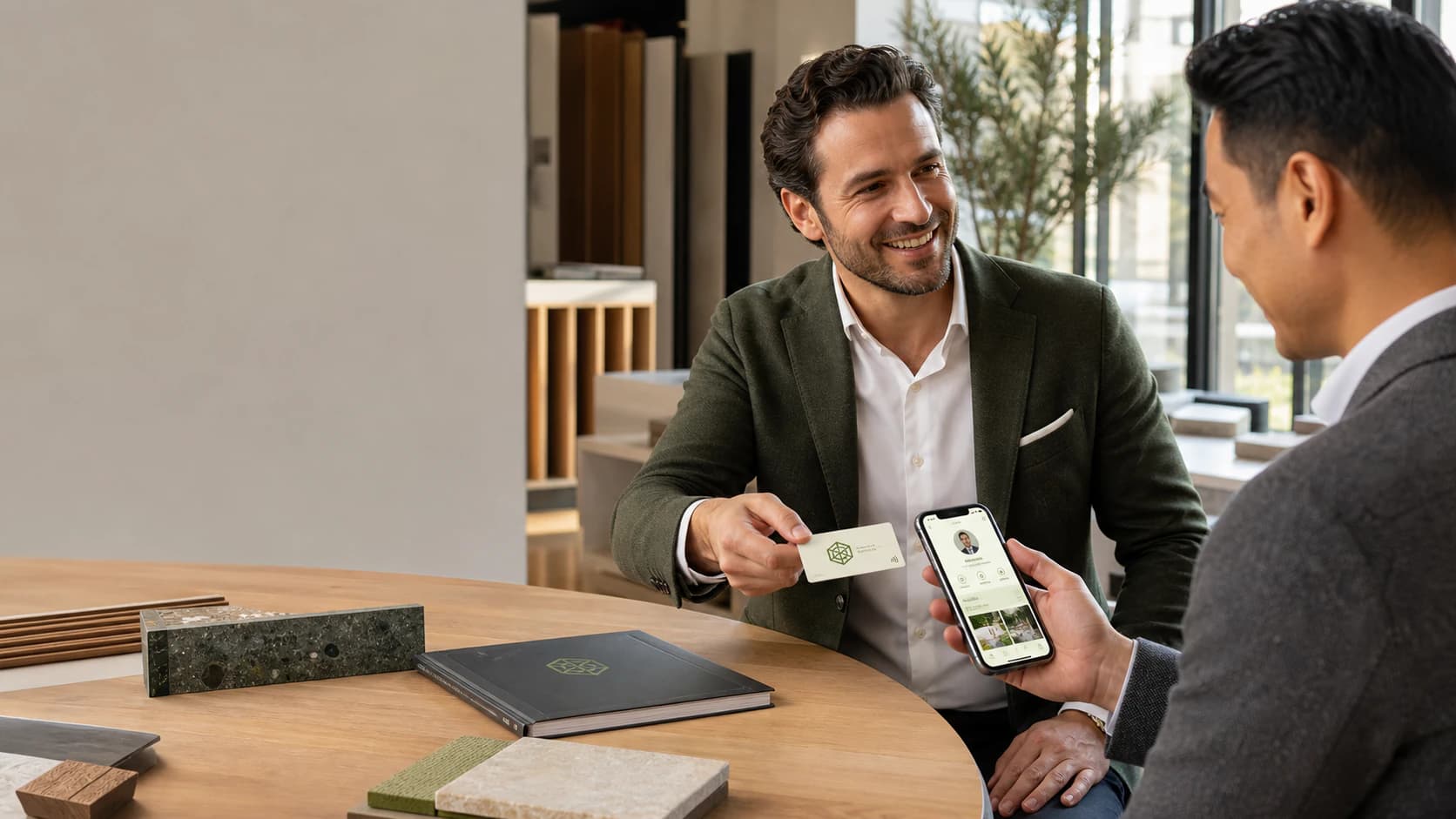 Agente commerciale consegna una card NFC con logo mentre il cliente consulta il profilo acceso sul telefono